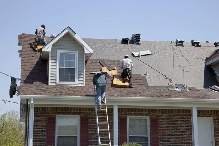 Roofing professionals installing shingles